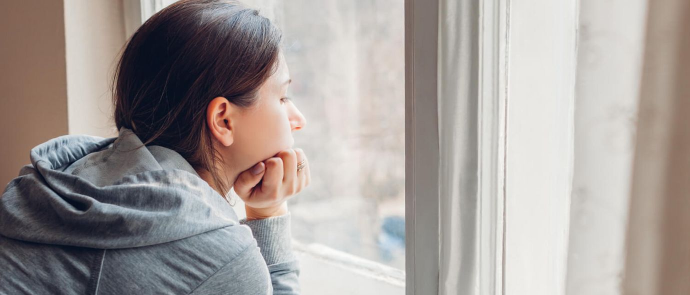 Traurige Frau schaut aus dem Fenster