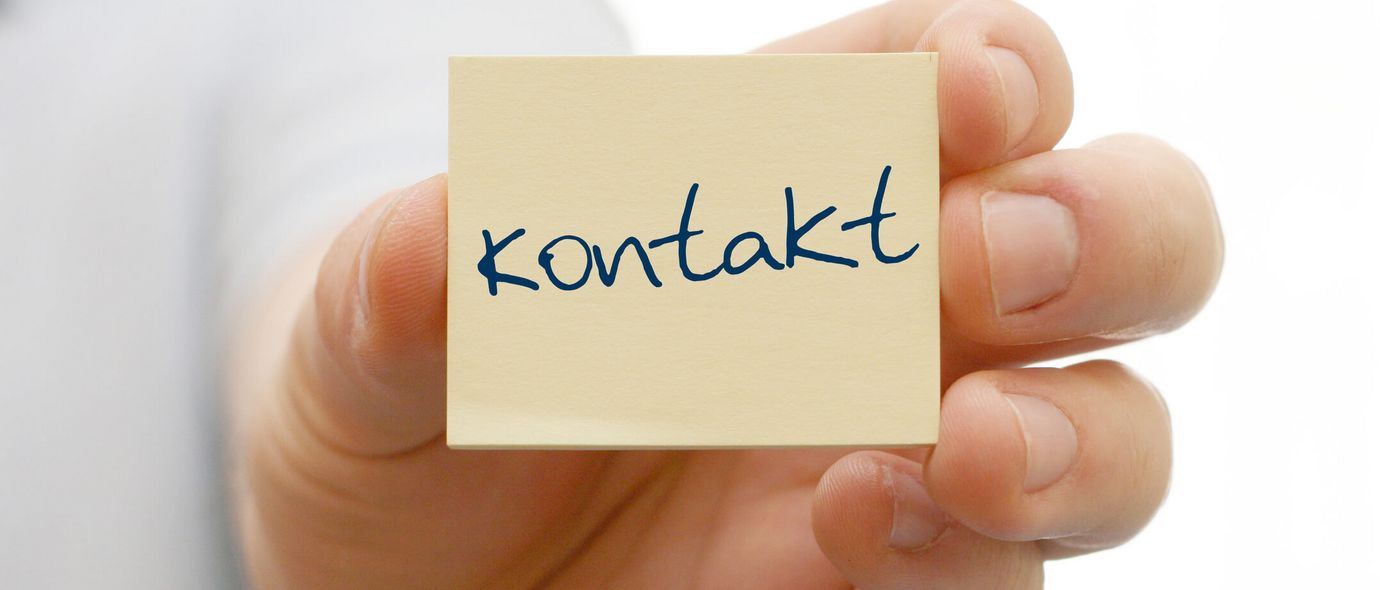 Hand hält Postit mit der Aufschrift Kontakt