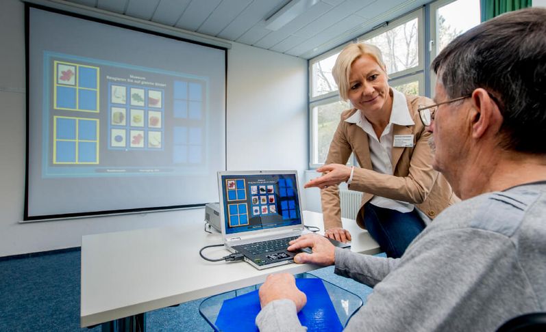Therapeutin untrestützt Patient beim Gedächtnistraining