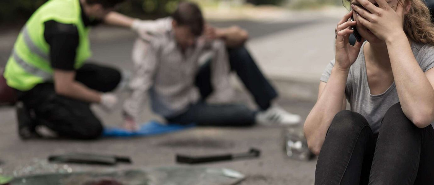 Helfer spricht mit Opfer nach Verkehrsunfall