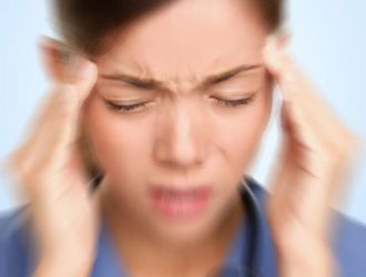 Frau hält ihre Schläfen wegen Kopfschmerzen