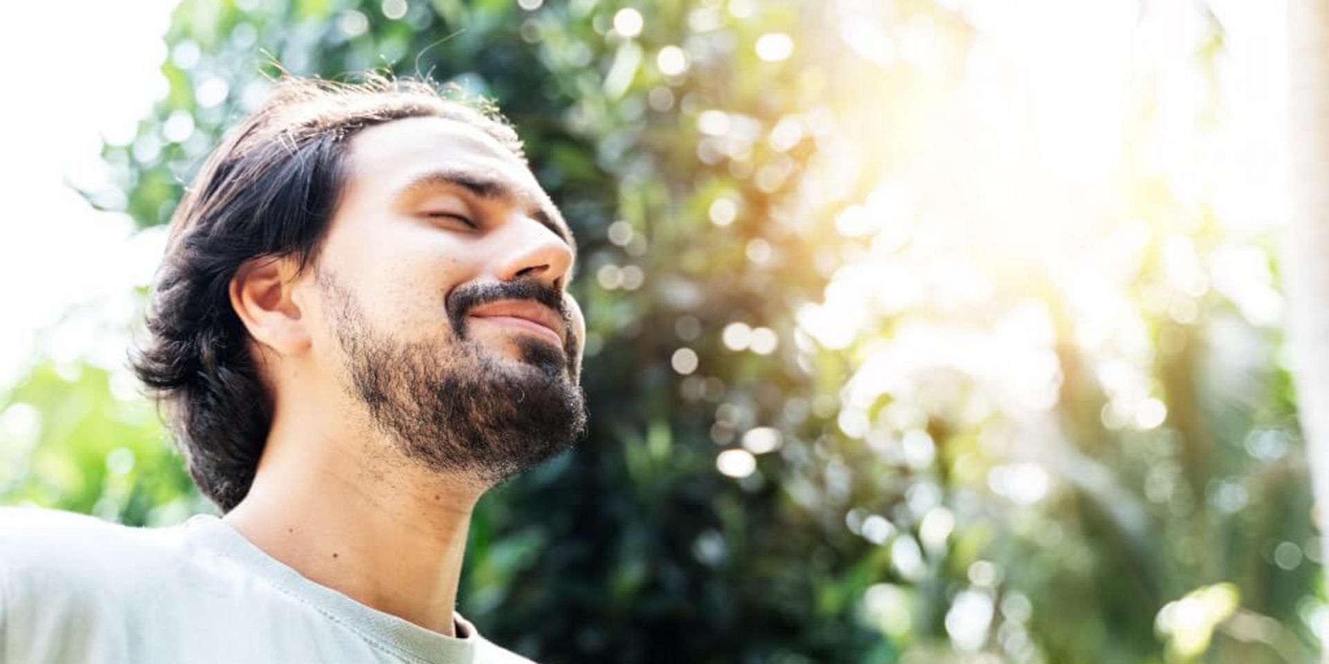 Ein bärtiger Mann meditiert an einem sonnigen Sommertag im Freie